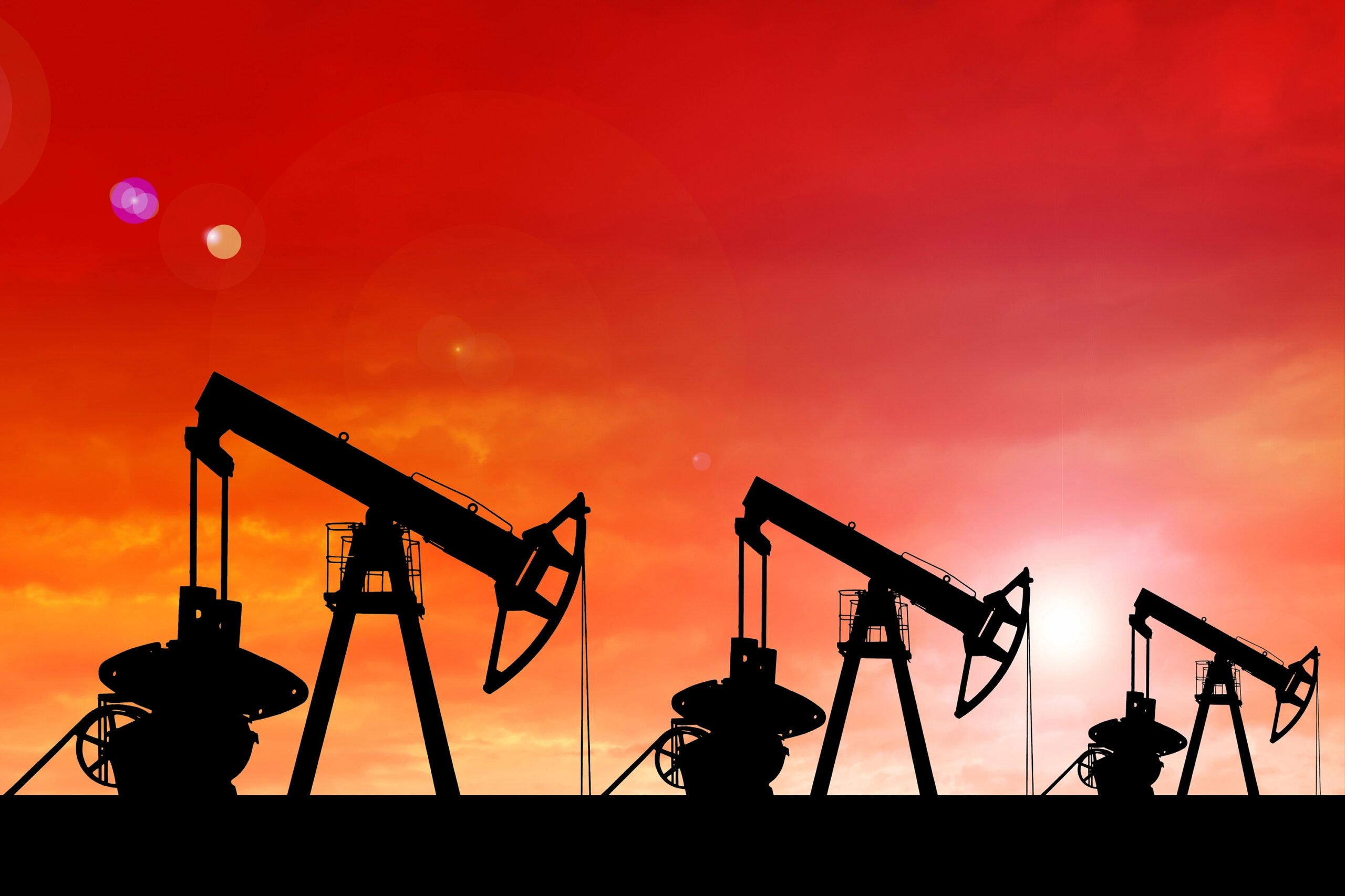Silhouette of oil pumps at sunset